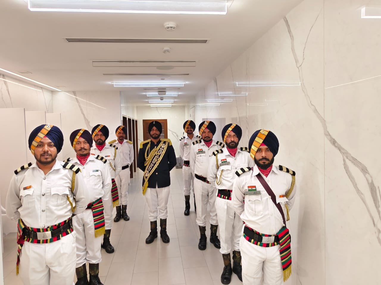 Royal Bagpipe Band members in white ceremonial uniforms